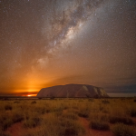 Milky Way rising over Uluru while a bushfire burns in the distance